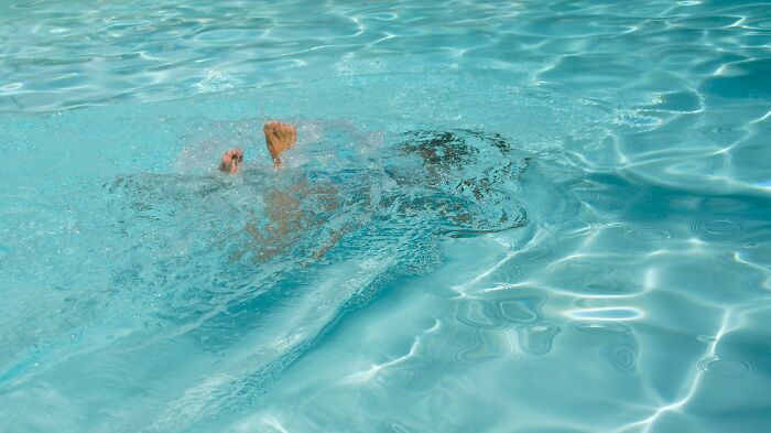 Person struggling underwater in a pool, depicting one of the scariest experiences people still can't believe happened to them.