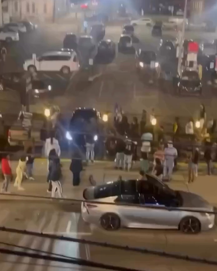 Multidão se reuniu na rua à noite enquanto veículos bloqueavam a estrada em Kentucky depois que uma mulher foi presa por dirigir no meio da multidão.