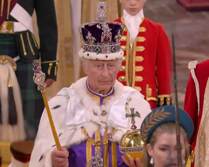 Senior royal wearing crown and robes during coronation ceremony, relating to lip reader revealing brutal takedown of Meghan Markle.