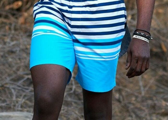 Person wearing striped blue shorts and wristbands outdoors, illustrating cultural differences people notice when visiting other countries.