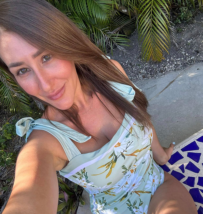 Jovem com vestido floral tirando uma selfie ao ar livre, relacionada a novos detalhes perturbadores no caso de morte violenta de uma enfermeira.