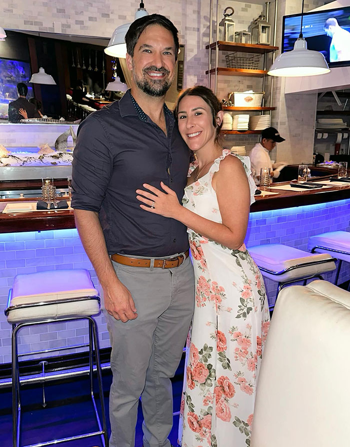 Casal posando em um restaurante com vestido floral e camisa escura, relacionado a detalhes perturbadores do caso de morte violenta de uma enfermeira.