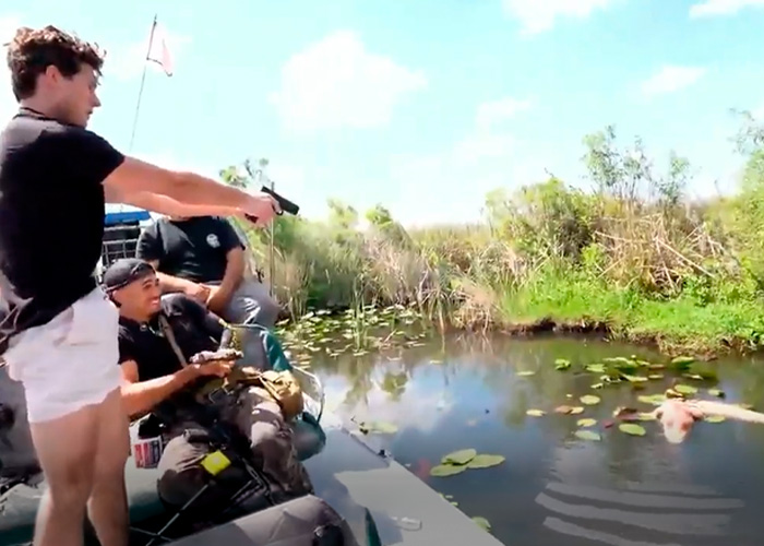 Controversial looksmaxxing influencer pointing a gun on a boat in Florida wetlands during an arrest situation.