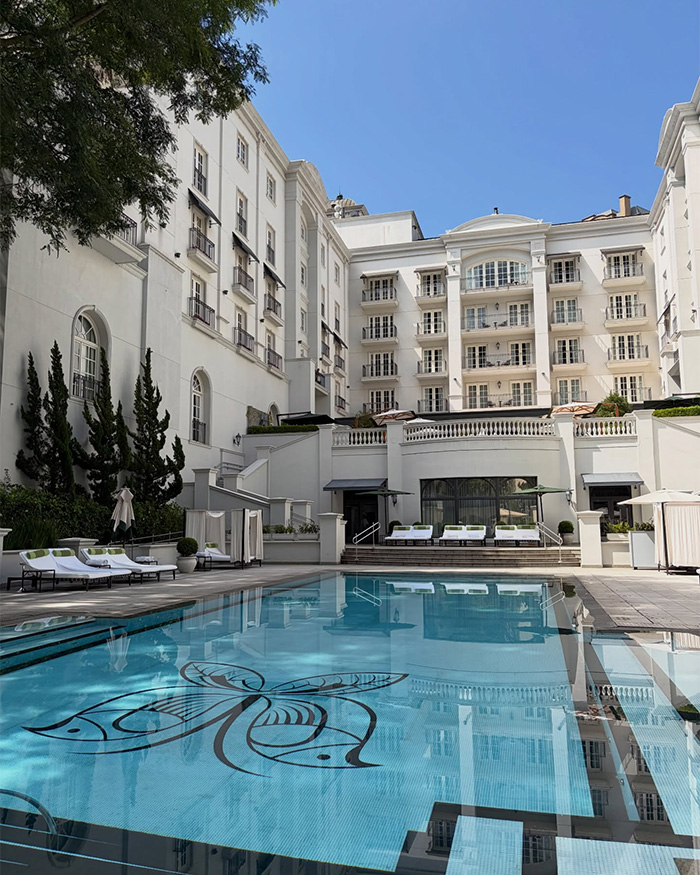 Luxury hotel pool area with white buildings, highlighting controversy involving Chappell Roan and Jude Law's daughter scandal. Luxury hotel pool area with white buildings, highlighting controversy involving Chappell Roan and Jude Law's daughter scandal.