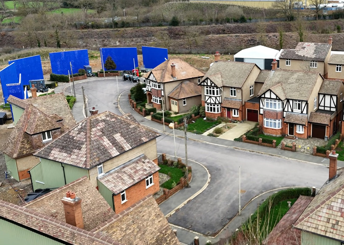 Aerial view of a film set with blue screens and Tudor-style houses revealing Harry Potter drone sneak details.