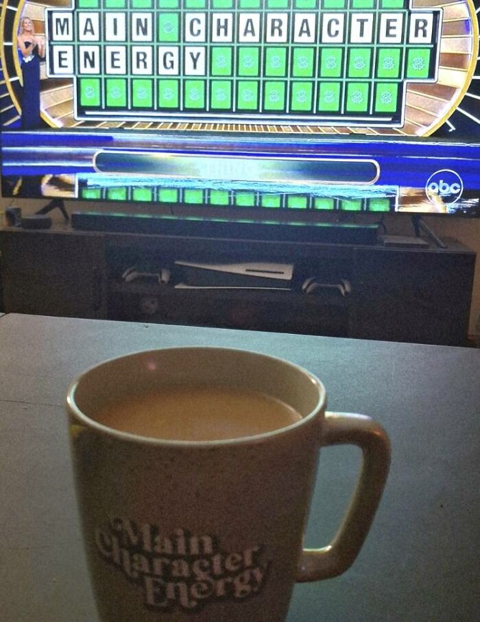 TV game show puzzle reading main character energy, coffee mug with similar phrase, highlighting odd and thought-provoking stories.