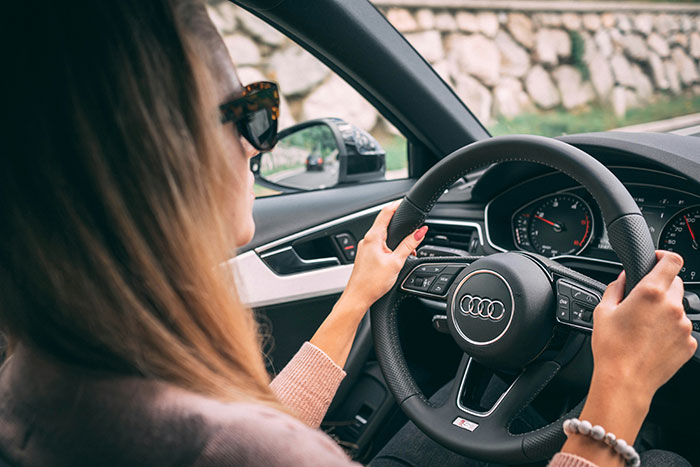 Woman driving an Audi car, evoking eerie and odd feelings related to unexplained stories and experiences.