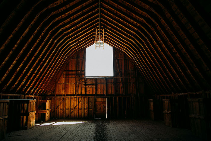 Dimly lit attic with wooden beams and an open window, evoking eerie and unexplained experiences atmosphere.