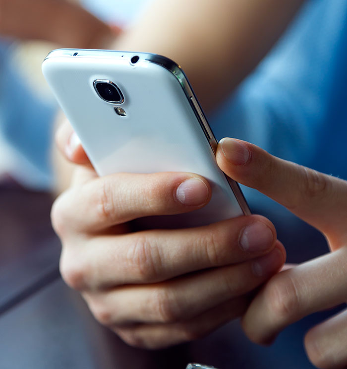Close-up of hands holding a smartphone, symbolizing eerie and odd stories about people experiencing unexplained things.