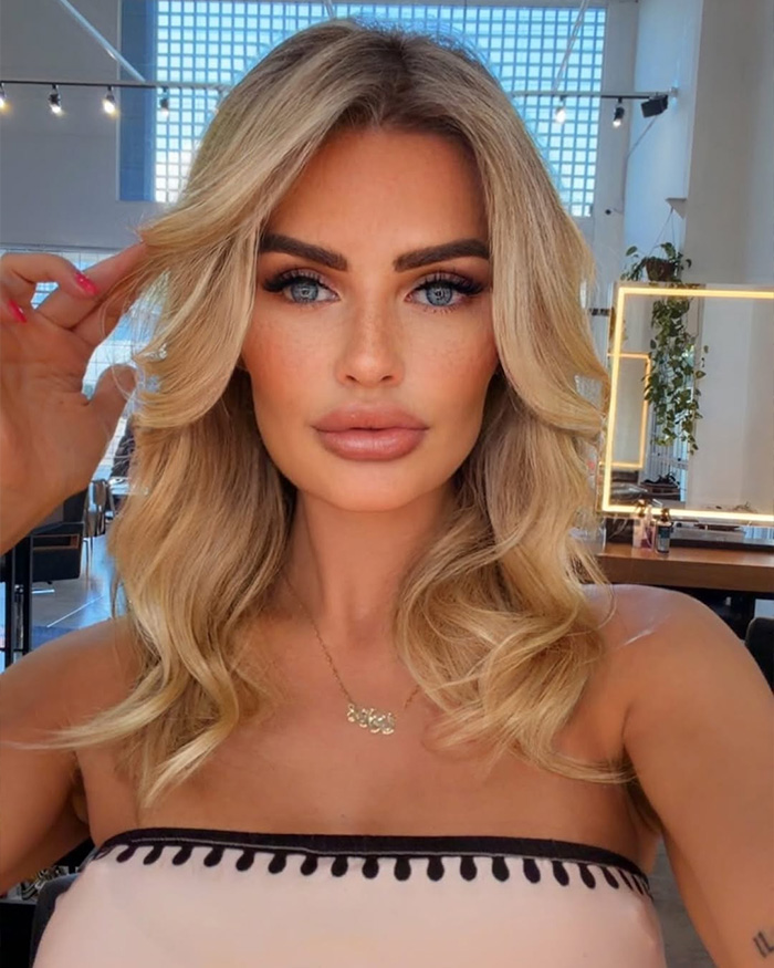 Influencer with blonde hair and blue eyes posing indoors after Disney World outfit sparked complaints and warnings.
