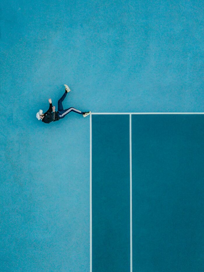 Aerial view of a person mid-fall on a blue sports court illustrating a scientific fact that might blow your mind.