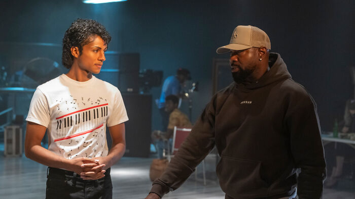 Two actors from the Michael movie cast discussing a scene on set for the Michael Jackson biopic.