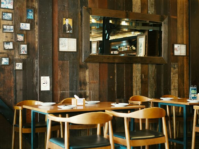 Cozy wooden dining area with wall photos and a mirror reflecting spooky details in a haunted place atmosphere.