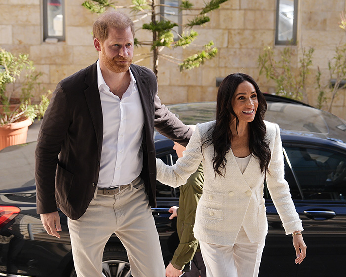 Prince Harry and Meghan Markle arriving together outdoors, related to lip reader revealing senior royals' takedown.