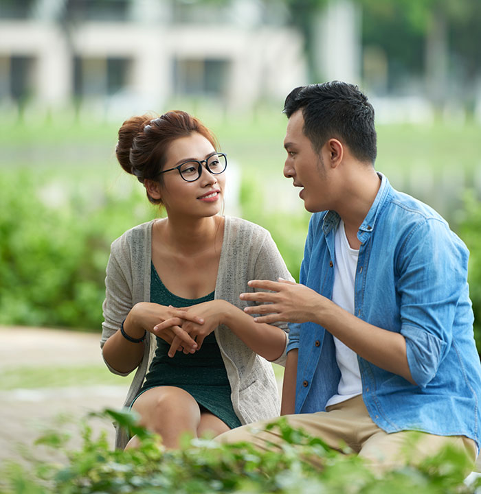 Young man and woman having a thoughtful conversation outdoors representing men dropping the Red Pill mindset.