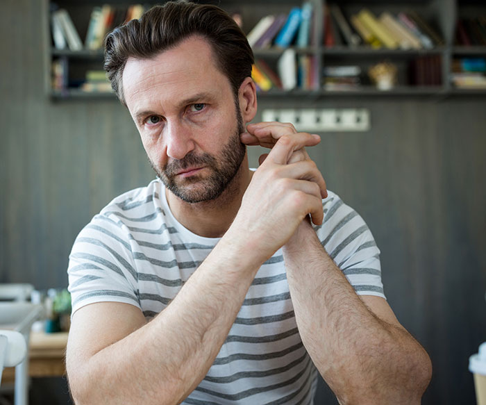 Man with a serious expression reflecting on the moment that made him drop the red pill mindset at home.