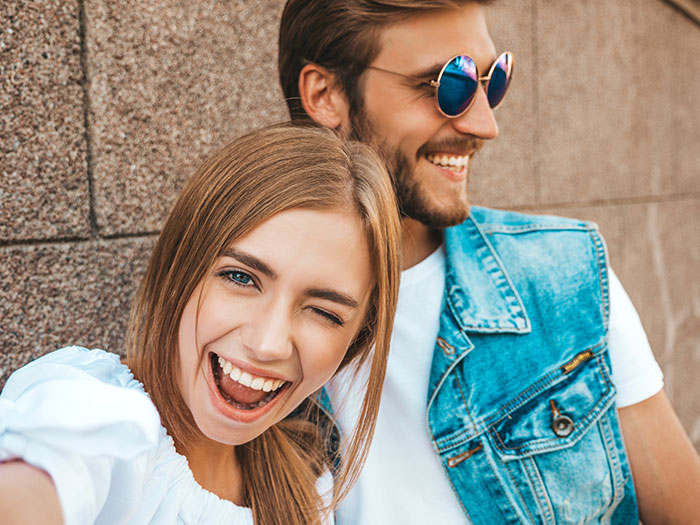 A happy couple smiling and having fun outdoors, illustrating moments related to the red pill mindset shift.