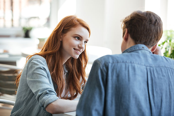 A man and woman engaged in a friendly conversation illustrating men dropping the red pill mindset concept.