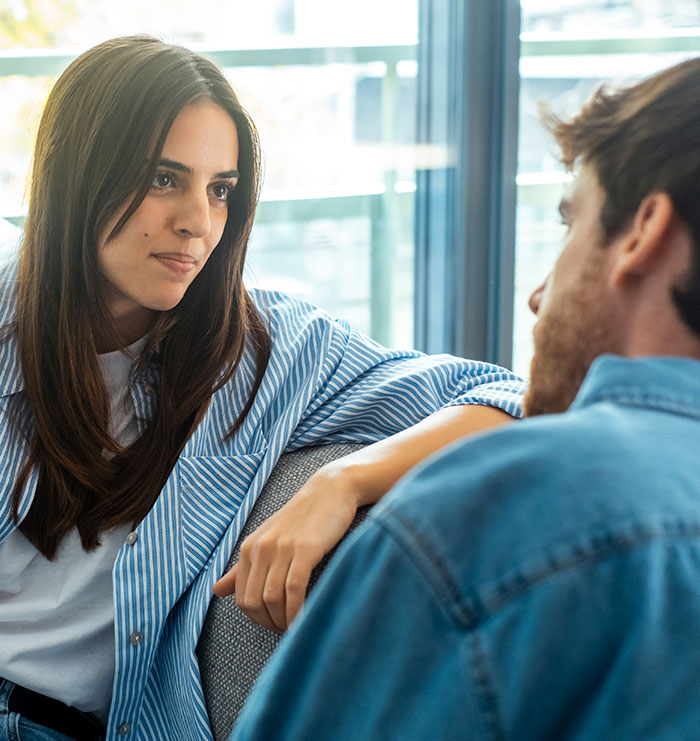 Young woman attentively listening to a man in a casual setting, reflecting moments that made men drop the red pill mindset.