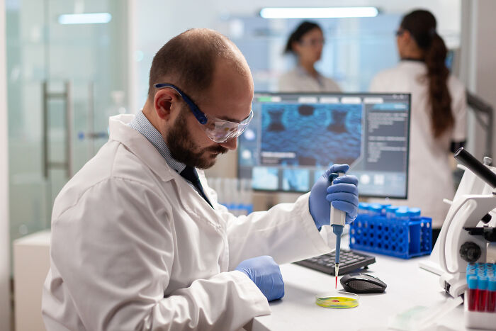 Scientist in a lab using a pipette for research, symbolizing wild discoveries that should spark outrage.