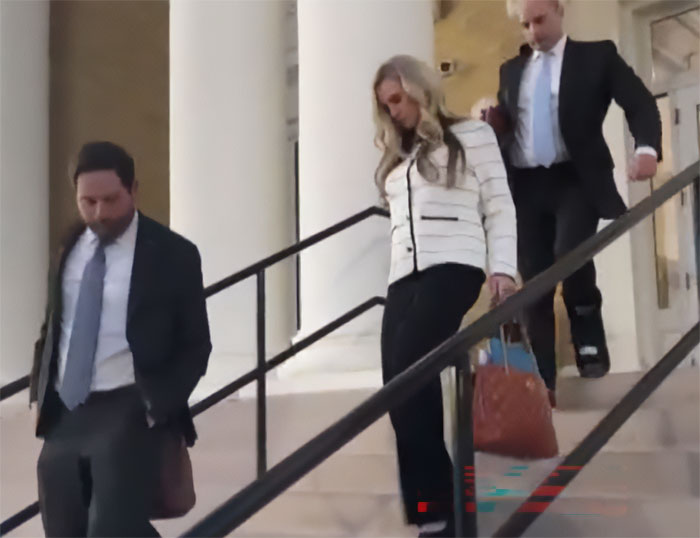 Former Louisiana mayor walking down courthouse steps with two men, facing legal consequences after pool party incident.