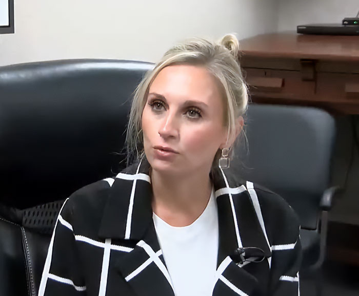 Former Louisiana mayor in a black and white jacket sitting in an office chair during a formal discussion.