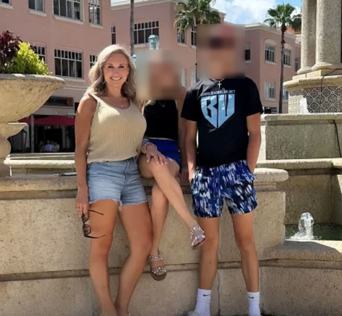 Former Louisiana mayor posing outdoors with two young people by a fountain, dressed casually in summer clothing.