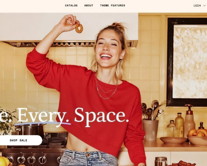 Model wearing red sweater in kitchen smiling, highlighting fashion brand plagiarism controversy involving AI photos.