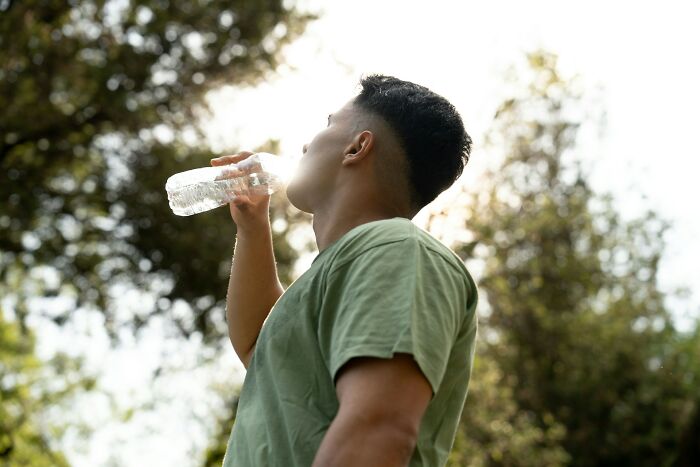 Young man drinking water outdoors, representing cases related to malfunctioning brain in dumb ER visits.