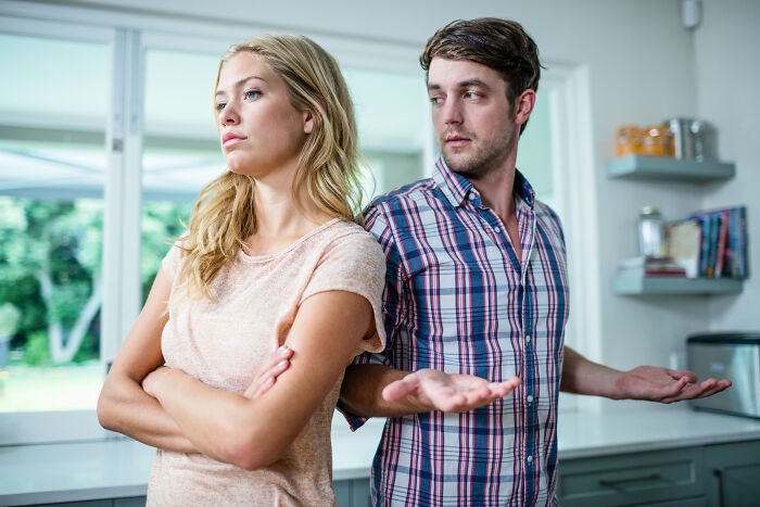 A frustrated couple in a kitchen showing nasty attitudes as they argue and disappoint each other.