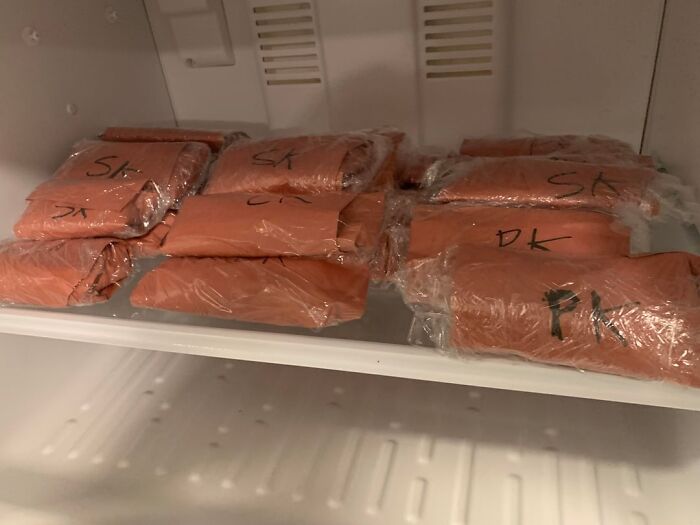 Wrapped packages labeled with markers stored inside a freezer, hinting at bizarre and creepy things found in old homes.