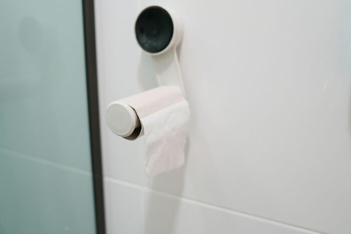 Empty toilet paper roll on holder in a bathroom, highlighting cultural differences people notice when visiting other countries.