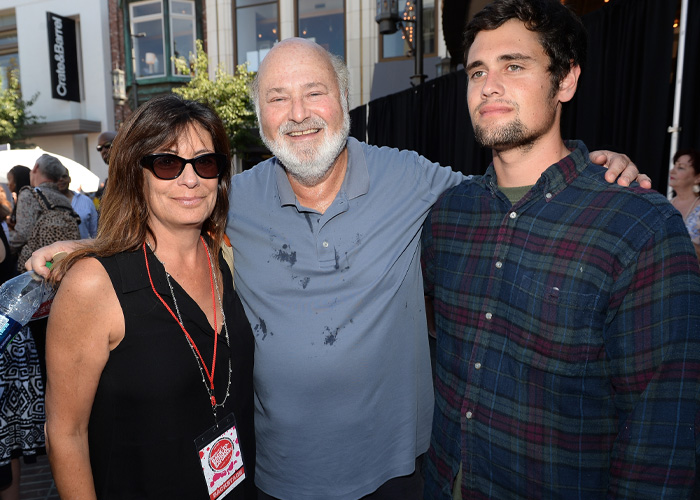 Three people posing together outdoors in casual clothes with Nick Reiner&rsquo;s account raising alarming questions theme implied.