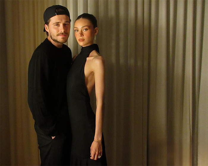 Brooklyn Beckham and Nicola Peltz posing together indoors with neutral curtains in the background, highlighting disturbing behavior concerns.