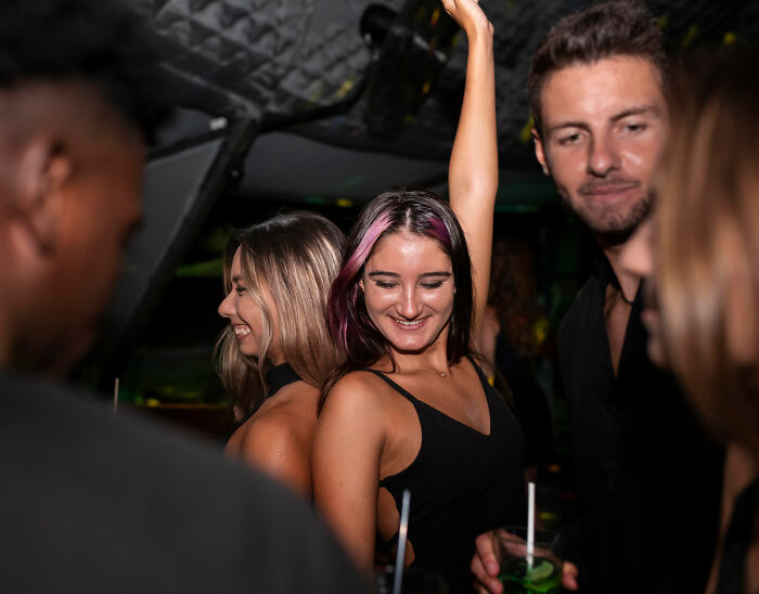 Group of young adults socializing and enjoying drinks at a night event, unrelated to mom arrested Universal Studios news.