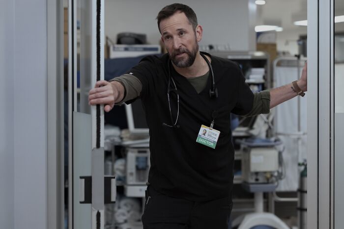 Man wearing black doctor scrubs with a stethoscope opening hospital doors in The Pitt Season 2 Episode 13 preview scene.