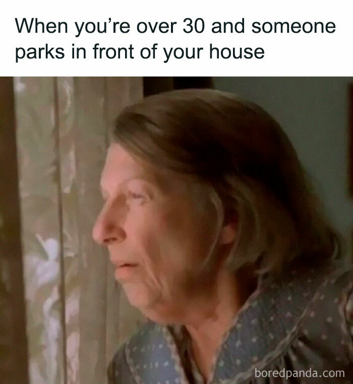 Older woman looking out window with a concerned face, relatable moment for millennials from childhood nostalgia posts.