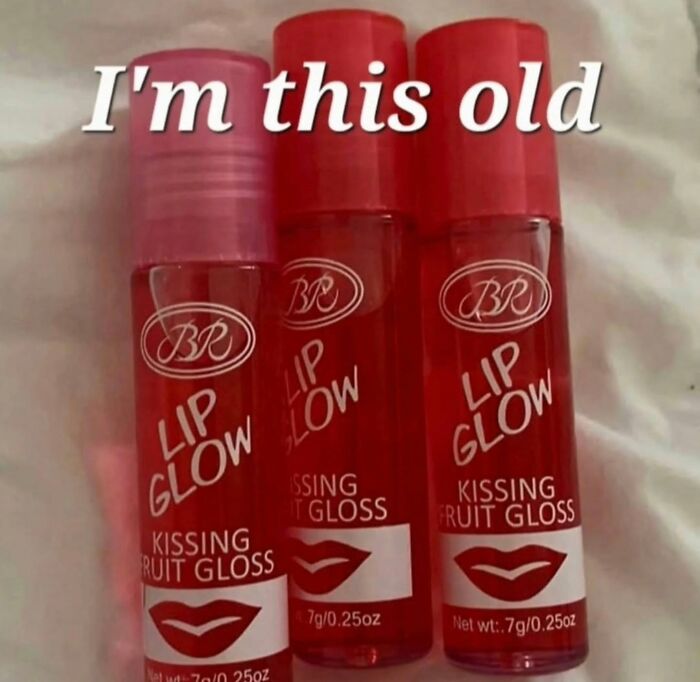 Three red BR Lip Glow kissing fruit gloss tubes on a soft surface, evoking millennial childhood nostalgia.