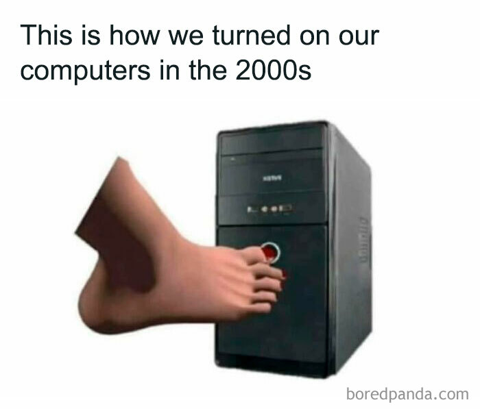 Foot pressing the power button on a 2000s computer tower, a nostalgic image for millennials' childhood memories.