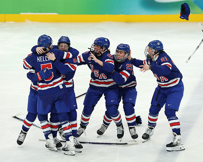 USA ice hockey players celebrating on ice, highlighting Olympic hero Jack Hughes' awkward interaction with the crowd. USA ice hockey players celebrating on ice, highlighting Olympic hero Jack Hughes' awkward interaction with the crowd.