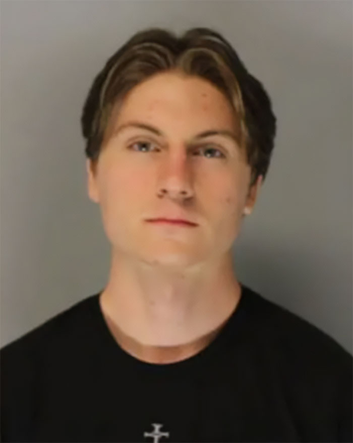Young man with light brown hair wearing a black shirt, connected to heartbreaking high school teacher prank details.