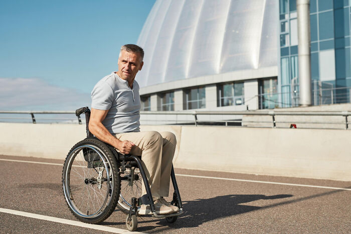 Man in a wheelchair on a city street representing empowerment in savage I literally own the company moments.