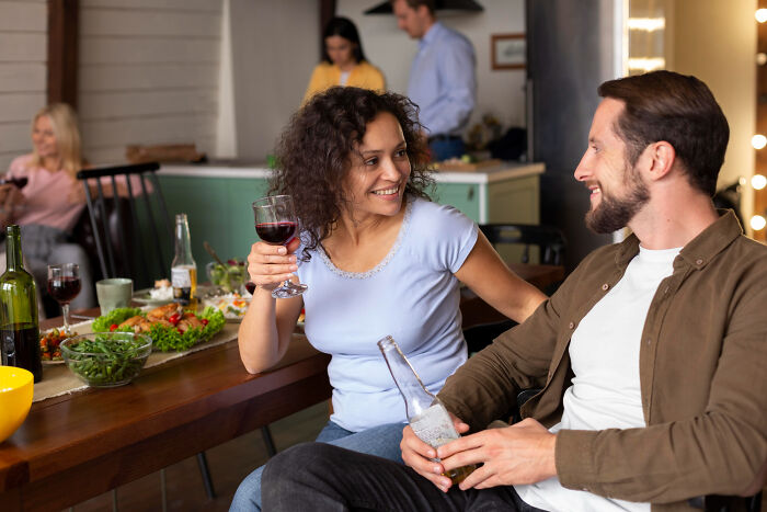 Two friends enjoy drinks and laughter at a casual gathering, capturing savage I literally own the company moments vibe.