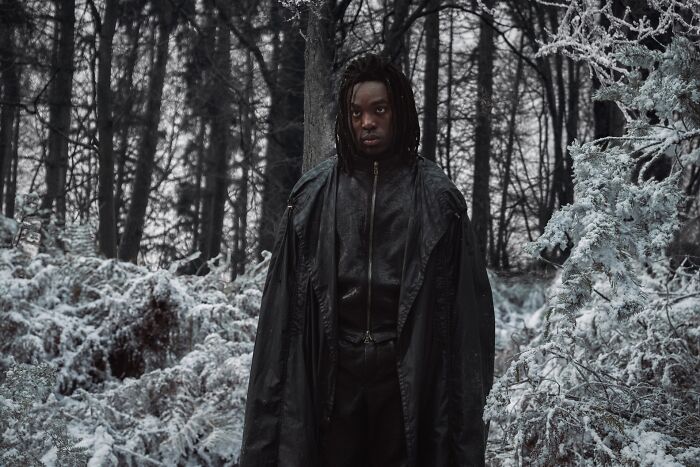 Young man dressed in dark cloak standing in snowy forest scene, promoting Harry Potter series trailer and cast updates. Young man dressed in dark cloak standing in snowy forest scene, promoting Harry Potter series trailer and cast updates.