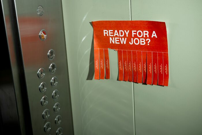 Red flyer with ready for a new job text inside an elevator, representing shaky industries that can collapse suddenly.