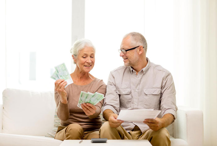 Elderly in-laws counting money and discussing finances, highlighting expectations around gifting money to the husband only.