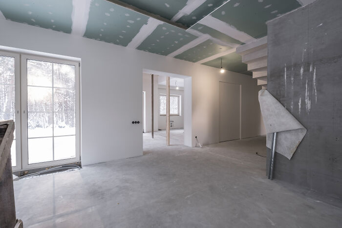 Empty unfinished room with drywall and construction materials during home renovation, representing old petty grudges concept.