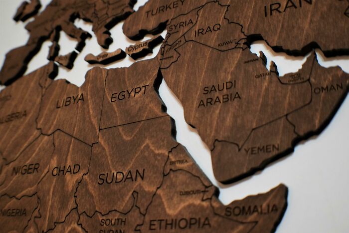 Wooden world geography map showing countries in North Africa and the Middle East to challenge your brain with geography questions.