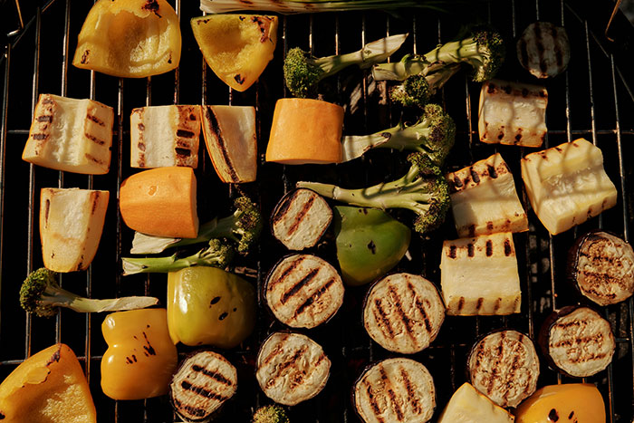 Grilled vegetables on a barbecue grill, highlighting vegan food options related to wife punishing vegan-hating husband story.