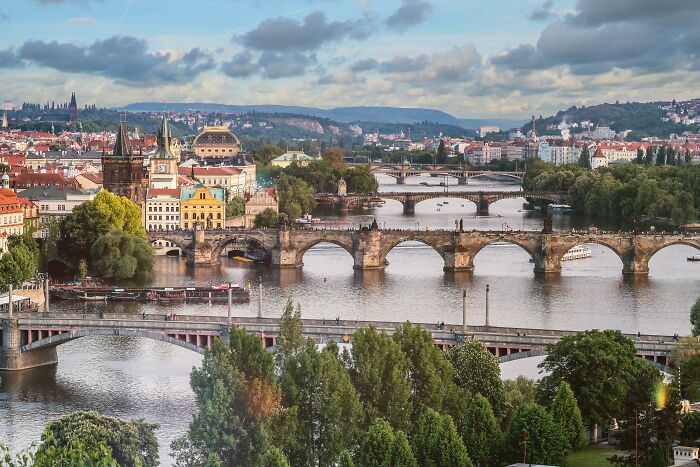 Historic bridges and river in a European city showcasing vanished cultural truths from people's home countries shared online.